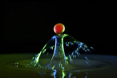 Close-up of illuminated lighting equipment against black background