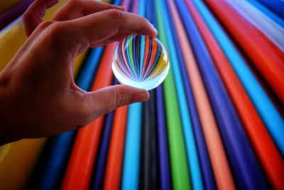 Low angle view of hand holding crystal ball