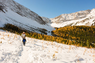 Woman with son walking over snow covered land