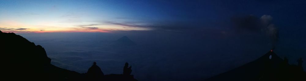 Silhouette of mountain against cloudy sky