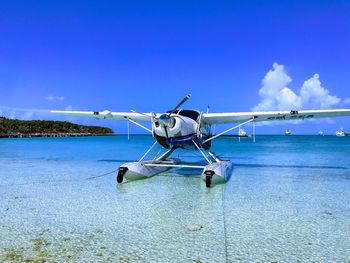 Airplane at airport against blue sky