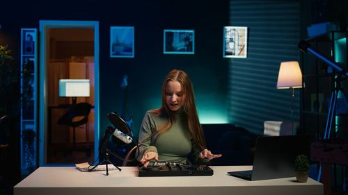 Portrait of young woman using mobile phone while sitting at cafe