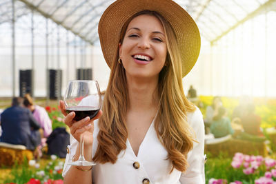 Woman looking at camera and holding glass of wine 