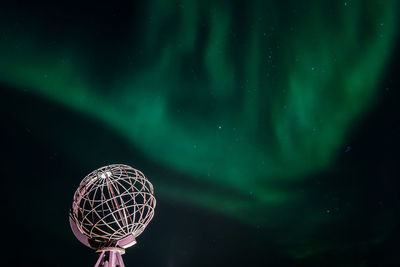 Low angle view of illuminated ferris wheel against sky at night