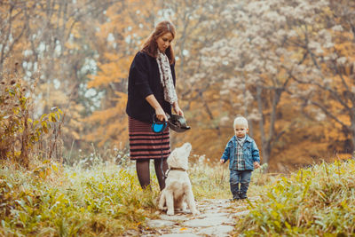 Rear view of people with dog during autumn