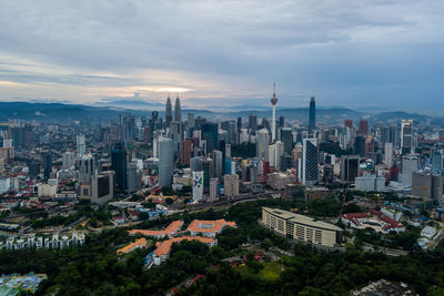 High angle view of buildings in city against cloudy sky