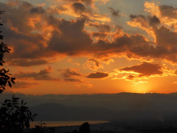 Scenic view of silhouette mountains against orange sky