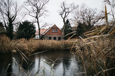 Houses by lake and building against sky