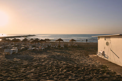 Scenic view of beach against clear sky during sunset