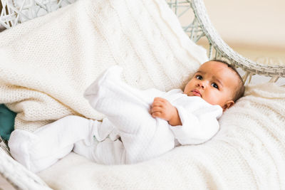 Portrait of cute baby lying on bed