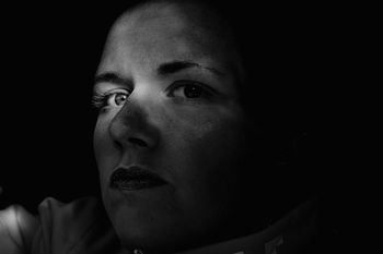 Close-up portrait of serious young woman against black background