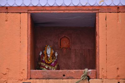 Statue by window of building