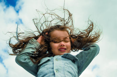 Portrait of happy girl against sky