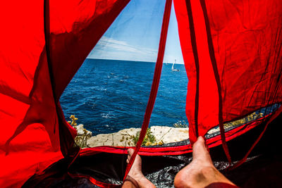 Low section of man in sea against sky