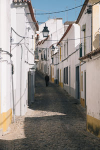 Street amidst houses against sky