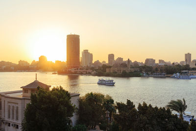 View of city at waterfront during sunset