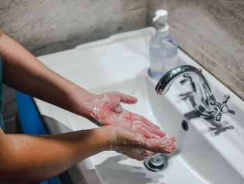 Midsection of woman in bathroom at home