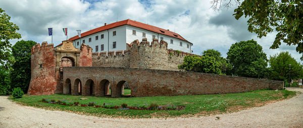 Exterior of old building by trees against sky