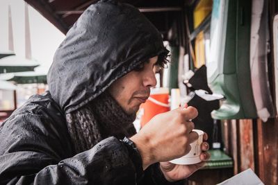 Portrait of young man holding sweet food outdoors