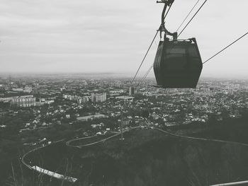 Overhead cable car over buildings against sky