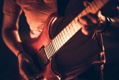 Midsection of man playing guitar