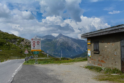 Road by mountains against sky