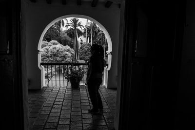 Rear view of man standing by door of building