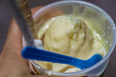 Close-up of hand holding bowl of soup