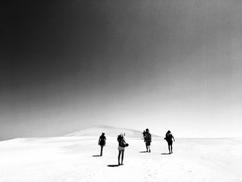 Rear view of people walking at desert
