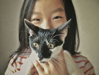 Portrait of young woman holding cat at home