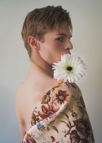 Close-up portrait of woman standing against white wall