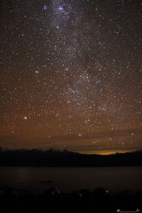 Scenic view of lake against sky at night