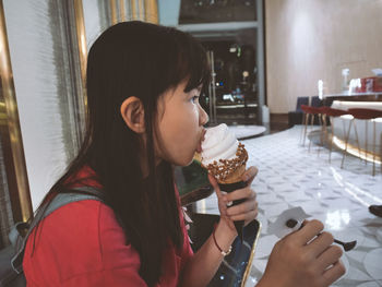 Girl licking ice cream in restaurant