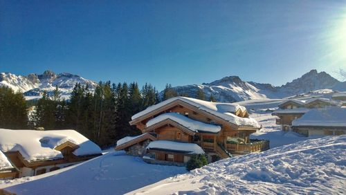 Houses on snowcapped mountain against sky