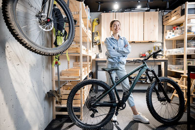 Full length portrait of young man standing in bicycle