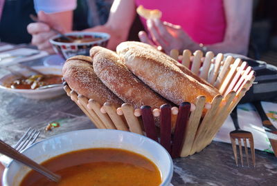 Basket with bread, food and drink on the table - unrecognizable people sitting at the table