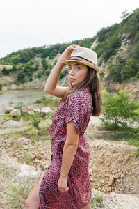 Side view of young woman standing on land