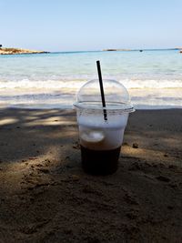 Drink on table at beach against sky