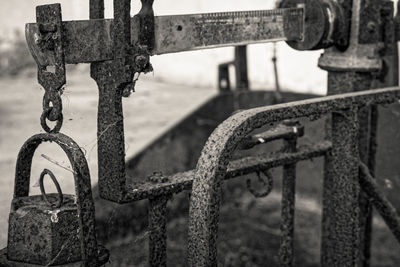 Close-up of rusty chain hanging on railing