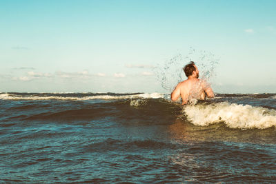 Man in ocean facing into a wave