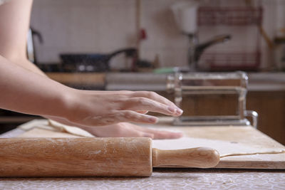 Cropped hands of man cutting board