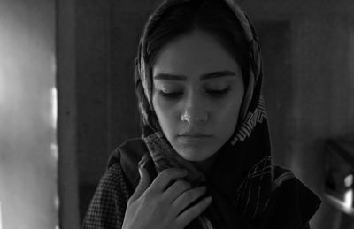 Close-up of woman wearing scarf at home