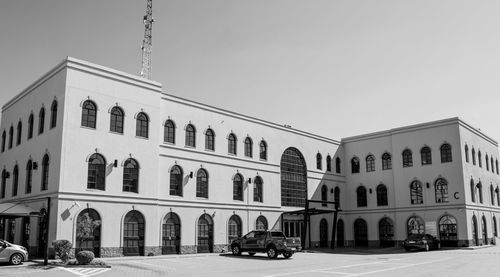 Cars on road by building against clear sky