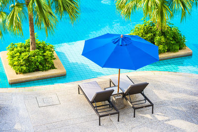 Chairs and tables by swimming pool