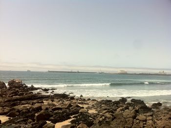 Scenic view of beach and sea against clear sky