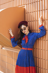 Young woman standing against wall