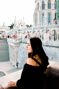 Side view of young woman looking at city