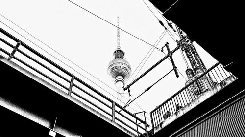 Low angle view of electricity pylon against building