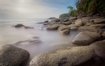 Rocks in sea against sky