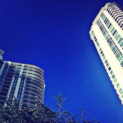 Low angle view of buildings against clear blue sky